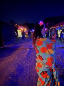 Pickleodeon camper in colorful floral outfit walking down lit pathway at night during SOAK