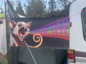 Colorful Possitopia theme camp banner featuring screaming possum with rainbow emanating from mouth