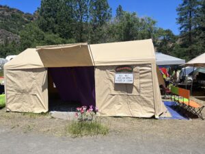 Pickleodeon outdoor movie theater tent with pickle sign, marquee, and purple curtain entrance at SOAK festival