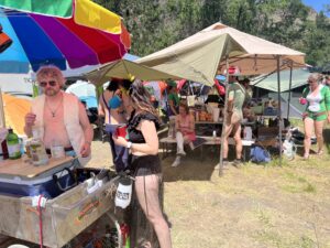 Pickleodeon bartender serving drinks from the rainbow umbrella cart while festival goers socialize